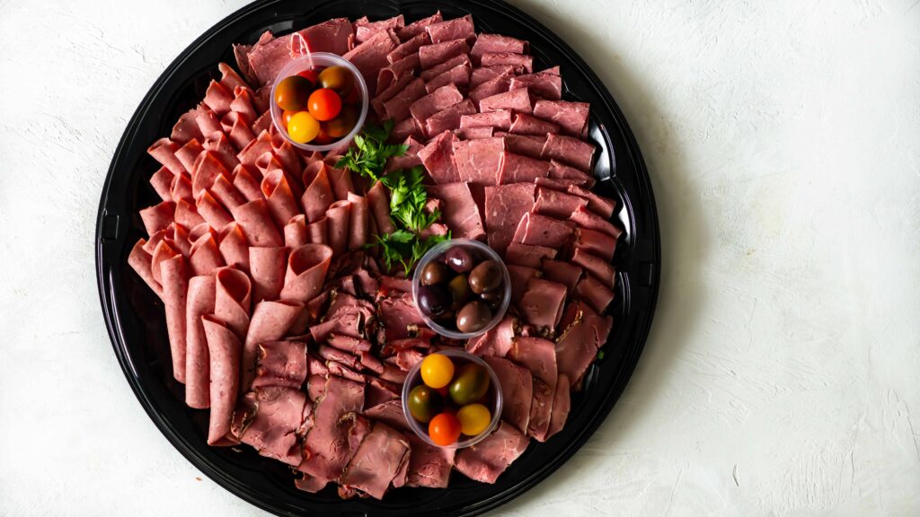 Slices of Corned Beef, Kosher Salami and New York Pastrami on a round catering tray