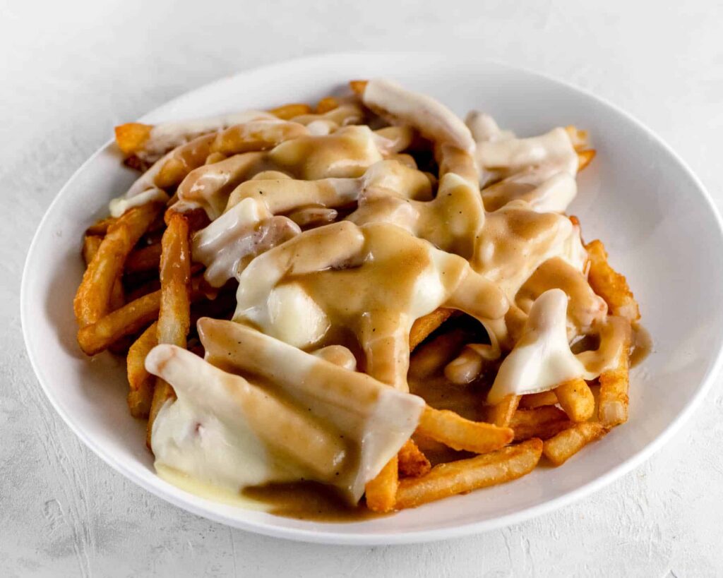 Plate of crispy fries topped with brown gravy and melted provolone cheese