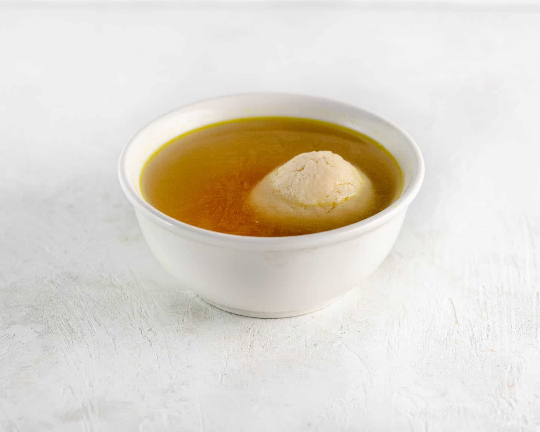 matzo soup in a white cup