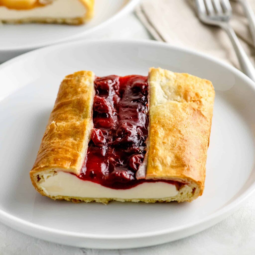 cherry and cheese danish on a white plate