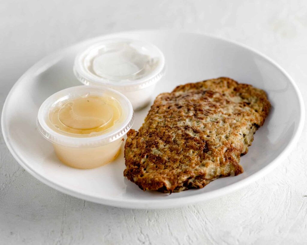 latke on a plate with sour cream and apple sauce