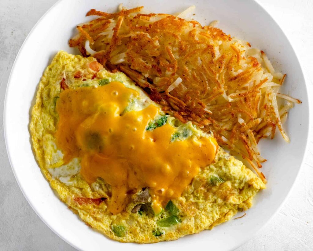build your own omelet with hashbrowns on a white plate