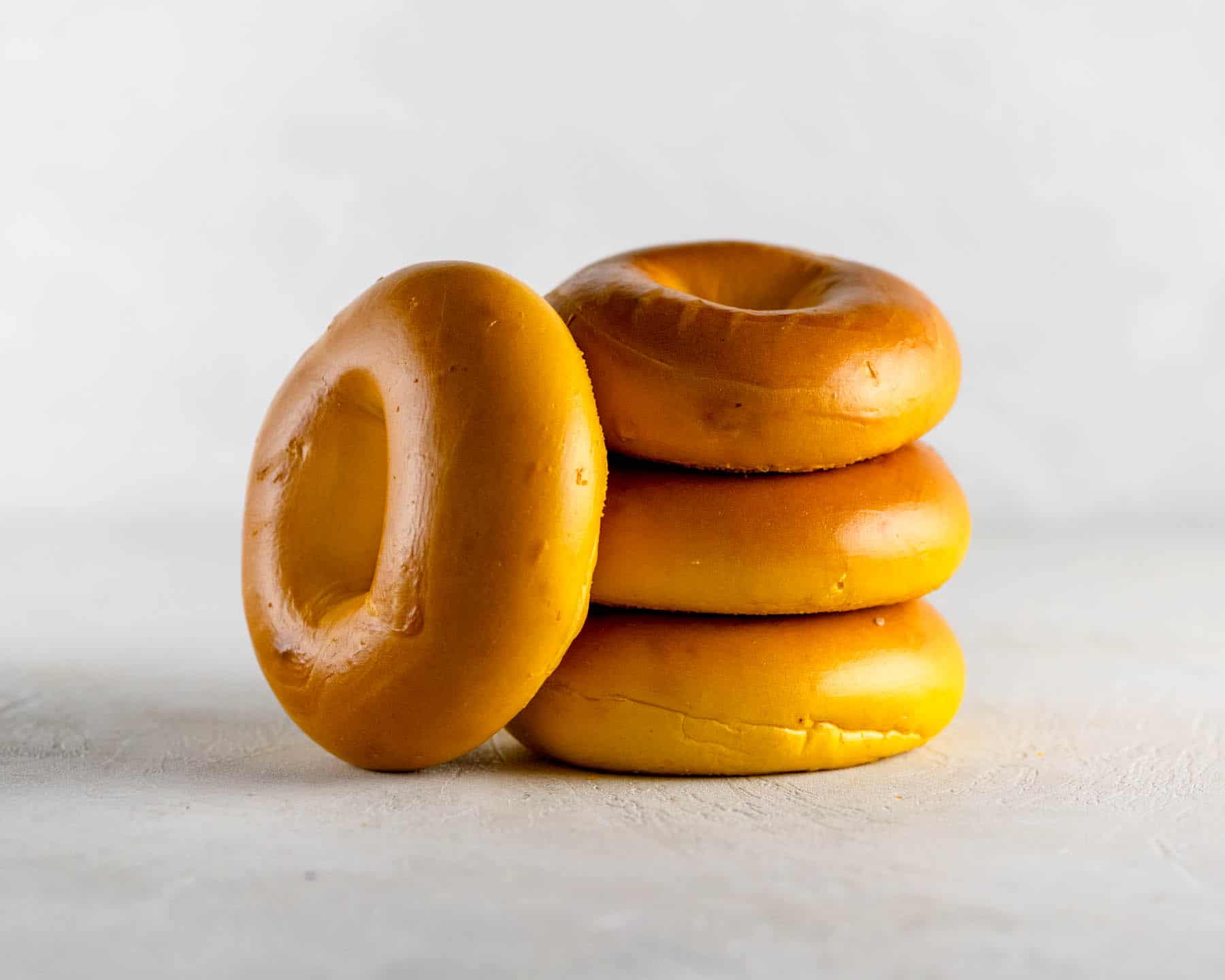 4 new york egg bagels stacked on a gray table